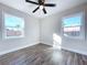 Bright bedroom with wood-look floors, ceiling fan, and two windows at 1709 Marilyn Ave, Bradenton, FL 34207