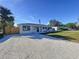 Newly renovated home with a large gravel driveway and a fenced backyard at 1709 Marilyn Ave, Bradenton, FL 34207