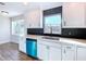 White kitchen features a teal dishwasher and hexagon backsplash at 1709 Marilyn Ave, Bradenton, FL 34207