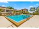 Inviting community pool with ample lounge chairs and nearby building view at 1812 Mariner Dr # 137, Tarpon Springs, FL 34689