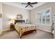 Cozy bedroom with a floral comforter, ceiling fan, and plantation shutters at 20716 Amanda Oak Ct, Land O Lakes, FL 34638