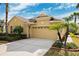 Tan single-story house with a two-car garage and lush landscaping at 20716 Amanda Oak Ct, Land O Lakes, FL 34638