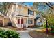 Two-story tan house with red door and landscaping at 2354 Tallyho Ln, Palm Harbor, FL 34683