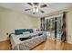 Bedroom with king-size bed, ceiling fan, and access to a patio at 30618 Birdhouse Dr, Wesley Chapel, FL 33545