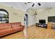 Living room with hardwood floors, a brown couch, and a vaulted ceiling at 30618 Birdhouse Dr, Wesley Chapel, FL 33545