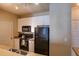 Kitchen with white cabinets, black appliances, and double sink at 4221 W Spruce St # 1212, Tampa, FL 33607