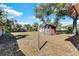 Spacious backyard with two sheds, mature trees, and a clothesline at 5711 S Coolidge Ave, Tampa, FL 33616