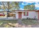 Front view of house with carport and red door at 5711 S Coolidge Ave, Tampa, FL 33616