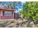 Brick ranch home with a spacious front yard, wood fence, and mature landscaping at 5711 S Coolidge Ave, Tampa, FL 33616