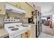 Bright kitchen features white appliances and view into the living room at 5711 S Coolidge Ave, Tampa, FL 33616