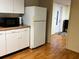 Bright kitchen features white cabinets, laminate flooring, and a refrigerator at 5711 S Coolidge Ave, Tampa, FL 33616