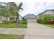 Tan house with blue accents, two-car garage, and landscaped yard at 6516 Salt Creek Ave, Apollo Beach, FL 33572