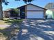 Single-story house with a white garage door and well-maintained lawn at 12172 Wild Acres Rd, Largo, FL 33773