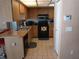 Kitchen with wood cabinets, black appliances, and a breakfast bar at 12172 Wild Acres Rd, Largo, FL 33773