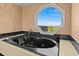 Luxurious bathroom with a large soaking tub and a window view at 1614 Sea Breeze Dr, Tarpon Springs, FL 34689