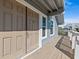 Elevated house entrance with a tan door and a wooden deck at 1614 Sea Breeze Dr, Tarpon Springs, FL 34689