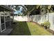 Small, grassy backyard with a privacy fence and mature trees at 1743 Arabian Ln, Palm Harbor, FL 34685