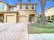 Tan two-story house with two-car garage, paver driveway, and American flag at 17523 Stinchar Dr # 17523, Land O Lakes, FL 34638