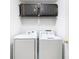 Functional laundry room with washer, dryer, and overhead storage at 17523 Stinchar Dr # 17523, Land O Lakes, FL 34638