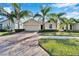 Single-story house with brick driveway and palm trees at 1861 Pacific Dunes Dr, Sun City Center, FL 33573