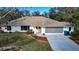 Single-story home with light-colored siding, a large driveway, and a well-manicured lawn at 195 Rusk Cir, Spring Hill, FL 34606