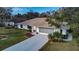Home's exterior boasts a spacious driveway and lush landscaping at 195 Rusk Cir, Spring Hill, FL 34606