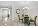 Elegant dining room with a round table, green velvet chairs, and a chandelier at 20011 Umbria Hill Dr, Tampa, FL 33647