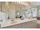 Double vanity bathroom with a large mirror and updated fixtures at 326 Caloosa Woods Ln, Sun City Center, FL 33573