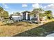 One-story house with landscaped yard, palm trees, and a screened entryway at 326 Caloosa Woods Ln, Sun City Center, FL 33573