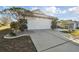 Front view of a house with a two-car garage and landscaping at 326 Caloosa Woods Ln, Sun City Center, FL 33573