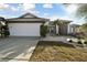 White and gray house with a two-car garage and well-manicured lawn at 326 Caloosa Woods Ln, Sun City Center, FL 33573