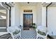 Front porch with white wicker chairs and patterned floor mat at 326 Caloosa Woods Ln, Sun City Center, FL 33573