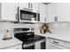 Stainless steel appliances and white cabinetry in modern kitchen at 3409 Santa Rita Ln, Land O Lakes, FL 34639