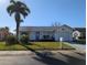 Single-story home with a palm tree, lawn, and attached garage at 4415 Great Lakes N Dr, Clearwater, FL 33762