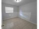 Simple bedroom with tile flooring and a window with blinds at 8533 Tidewater Trl, Tampa, FL 33619