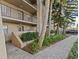 Exterior view of condo building with landscaped walkway and parking at 90 S Highland Ave # 102, Tarpon Springs, FL 34689