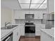 Modern kitchen with white cabinets, stainless steel appliances, and marble countertops at 90 S Highland Ave # 102, Tarpon Springs, FL 34689
