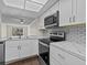 Modern kitchen with white cabinets, stainless steel appliances, and marble countertops at 90 S Highland Ave # 102, Tarpon Springs, FL 34689