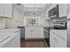Modern kitchen with white cabinets, stainless steel appliances, and marble countertops at 90 S Highland Ave # 102, Tarpon Springs, FL 34689