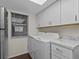 Laundry room with washer, dryer, and white cabinets at 90 S Highland Ave # 102, Tarpon Springs, FL 34689