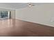Spacious living room featuring wood-look floors and access to a balcony at 90 S Highland Ave # 102, Tarpon Springs, FL 34689