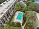 Community pool with surrounding patio and landscaping at 90 S Highland Ave # 102, Tarpon Springs, FL 34689