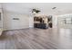 Spacious living room with wood-look floors, sliding doors to pool, and open kitchen view at 11201 Mercedes St, Spring Hill, FL 34609
