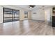 Spacious living room with wood-look floors, sliding doors to pool area, and ceiling fan at 11201 Mercedes St, Spring Hill, FL 34609