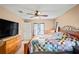 Bright bedroom with ceiling fan and large TV at 12404 Dolquieb Ln, Weeki Wachee, FL 34614