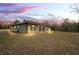 Green house exterior at dusk with landscape at 12404 Dolquieb Ln, Weeki Wachee, FL 34614
