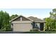 Single-story house with gray siding, two-car garage, and landscaping at 17283 Whiskey Creek Trl, Parrish, FL 34219