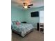 Light teal bedroom with a queen bed, desk, and window at 17818 Althea Blue Pl, Lutz, FL 33558