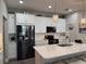 Modern kitchen with white cabinets, granite counters, and stainless steel appliances at 17818 Althea Blue Pl, Lutz, FL 33558