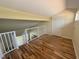 Bright loft bedroom featuring wood floors and a private door at 2066 Sunset Point Rd # 97, Clearwater, FL 33765